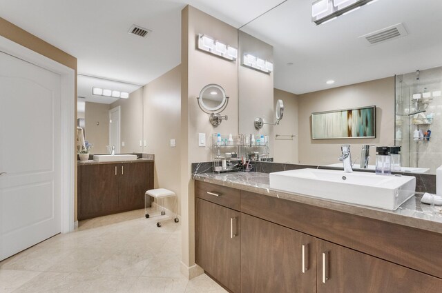 bathroom with tile patterned floors, visible vents, two vanities, and a sink