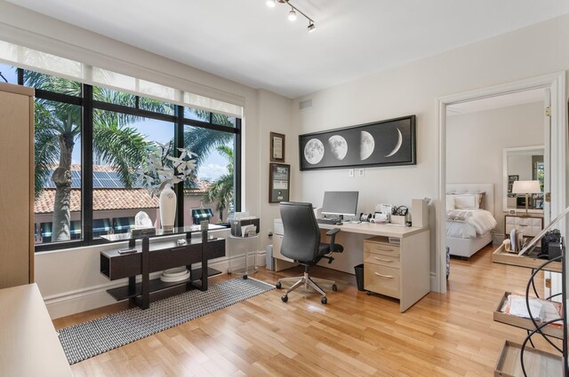 office area with light wood-style floors and visible vents