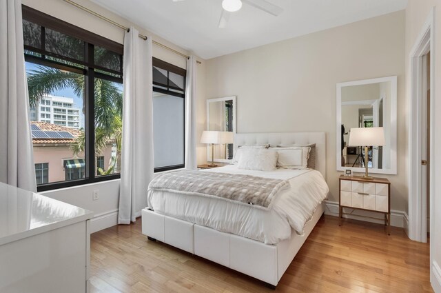 bedroom featuring baseboards, ceiling fan, and light wood finished floors