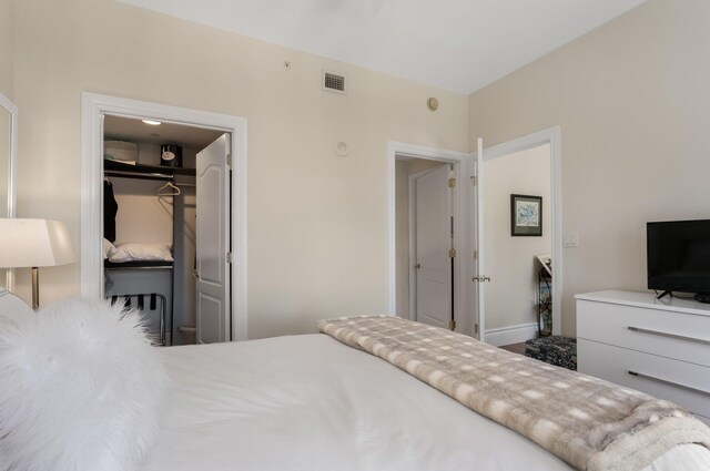 bedroom with visible vents, a walk in closet, and a closet