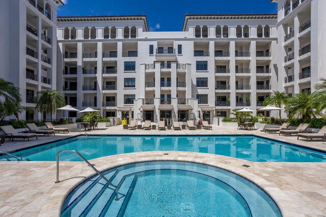 community pool featuring a patio and a hot tub