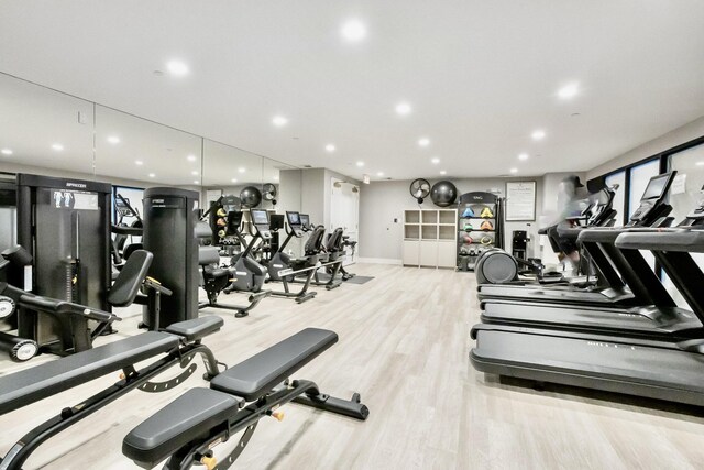 workout area featuring baseboards, recessed lighting, and wood finished floors