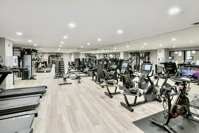 workout area featuring recessed lighting, light wood-type flooring, and visible vents