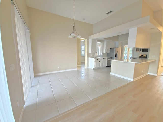 10902 SW Blue Mesa Way, Port Saint Lucie, FL 34987 - kitchen with stainless steel appliances, a chandelier, light countertops, white cabinets, and open floor plan