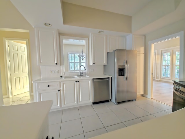 10902 SW Blue Mesa Way, Port Saint Lucie, FL 34987 - kitchen with appliances with stainless steel finishes, white cabinets, light countertops, a chandelier, and light tile patterned floors