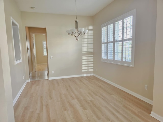 10902 SW Blue Mesa Way, Port Saint Lucie, FL 34987 - unfurnished dining area with light wood-style flooring and a chandelier