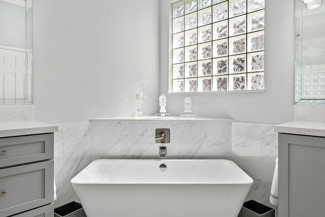 10740 Grande Blvd, West Palm Beach, FL 33412 - bathroom with tile walls, a freestanding tub, and vanity