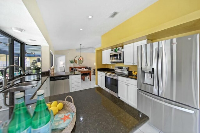 870 SW Gardens Blvd, Palm City, FL 34990 - kitchen featuring visible vents, a sink, a peninsula, appliances with stainless steel finishes, and white cabinetry