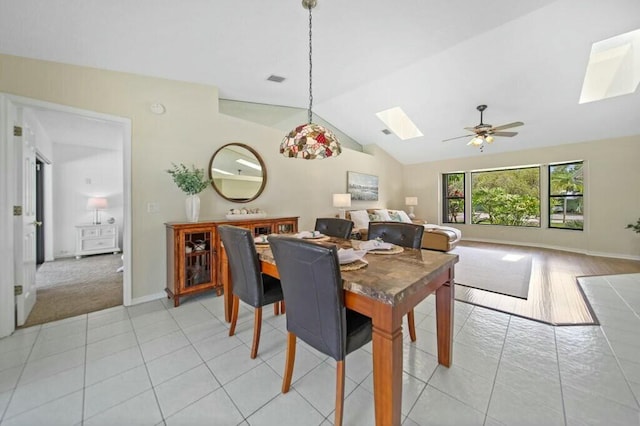 870 SW Gardens Blvd, Palm City, FL 34990 - dining room featuring ceiling fan, baseboards, light tile patterned flooring, and lofted ceiling with skylight
