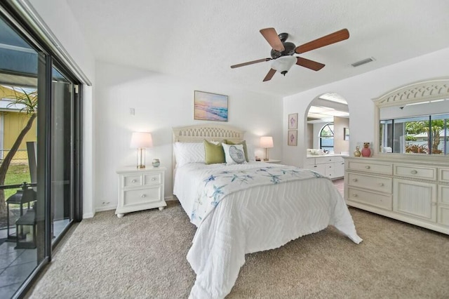 870 SW Gardens Blvd, Palm City, FL 34990 - bedroom featuring access to outside, visible vents, arched walkways, carpet flooring, and ceiling fan