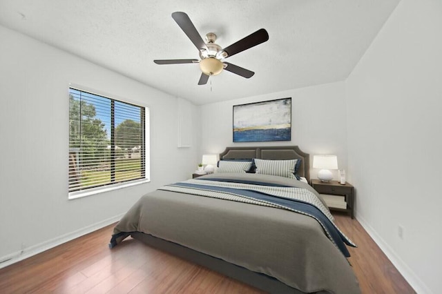 870 SW Gardens Blvd, Palm City, FL 34990 - bedroom with ceiling fan, baseboards, wood finished floors, and a textured ceiling
