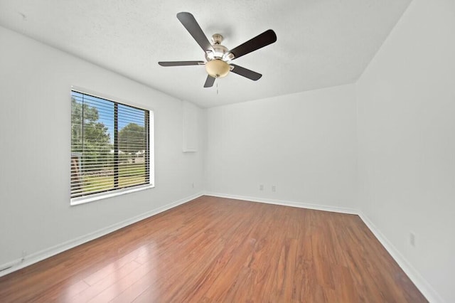 870 SW Gardens Blvd, Palm City, FL 34990 - spare room with wood finished floors, a ceiling fan, and baseboards