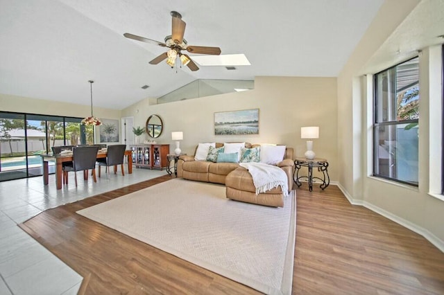 870 SW Gardens Blvd, Palm City, FL 34990 - living area with vaulted ceiling, a ceiling fan, baseboards, and wood finished floors