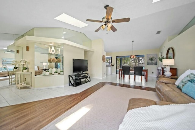 870 SW Gardens Blvd, Palm City, FL 34990 - living room featuring tile patterned flooring, vaulted ceiling with skylight, visible vents, and a ceiling fan