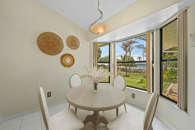 870 SW Gardens Blvd, Palm City, FL 34990 - dining area featuring light tile patterned flooring, vaulted ceiling, a healthy amount of sunlight, and baseboards