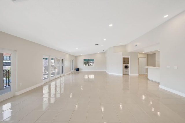 unfurnished living room with washer / clothes dryer, recessed lighting, baseboards, and light tile patterned floors