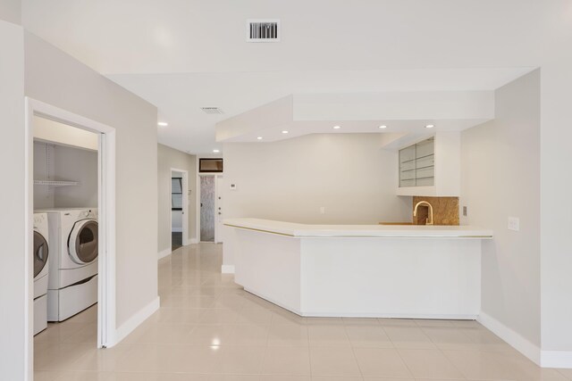 kitchen featuring washing machine and clothes dryer, recessed lighting, and baseboards