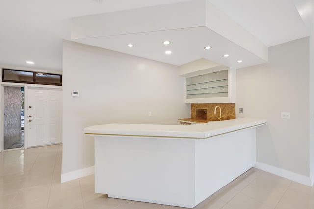 kitchen featuring a peninsula, baseboards, light tile patterned floors, and recessed lighting