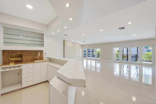 kitchen featuring visible vents, open floor plan, a sink, and light tile patterned floors