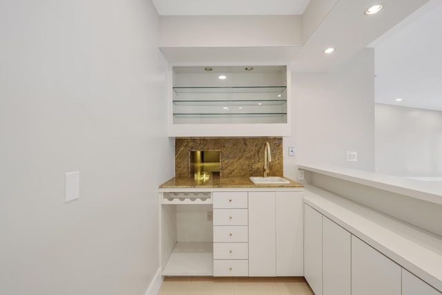 bar featuring wet bar, tasteful backsplash, a sink, light tile patterned floors, and recessed lighting