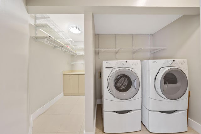 laundry area featuring light tile patterned floors, baseboards, laundry area, and washing machine and dryer