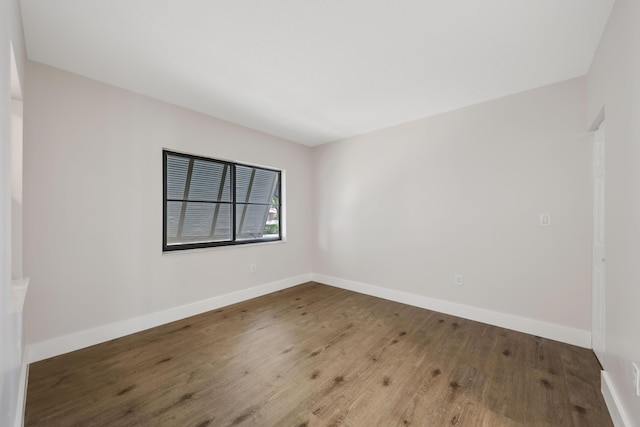 empty room featuring baseboards and wood finished floors