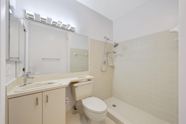 full bathroom featuring vanity, tile patterned floors, toilet, and tiled shower