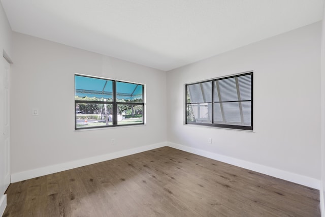 empty room featuring baseboards and wood finished floors