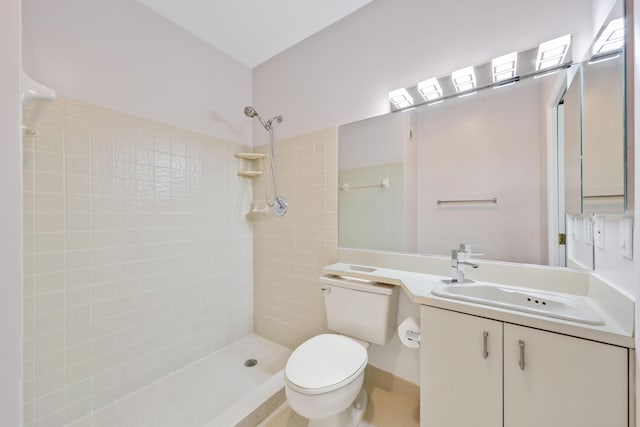 bathroom featuring vanity, toilet, and tiled shower