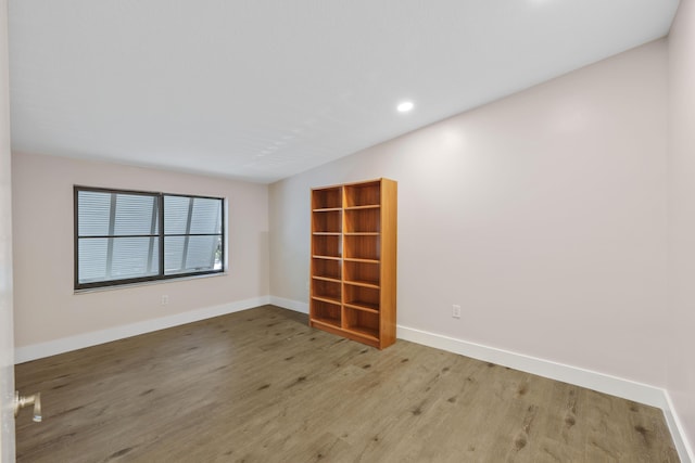spare room with recessed lighting, baseboards, and wood finished floors