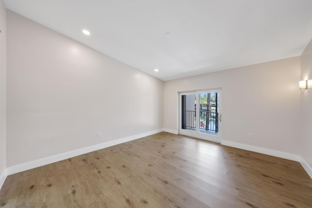 spare room with recessed lighting, baseboards, and wood finished floors
