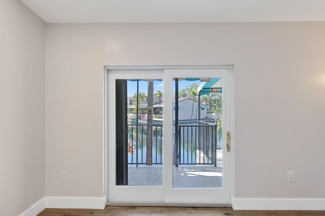 doorway to outside with baseboards and wood finished floors