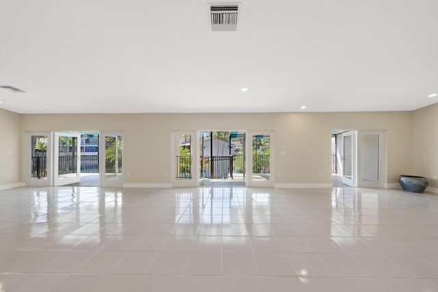 empty room with visible vents, light tile patterned floors, and a wealth of natural light