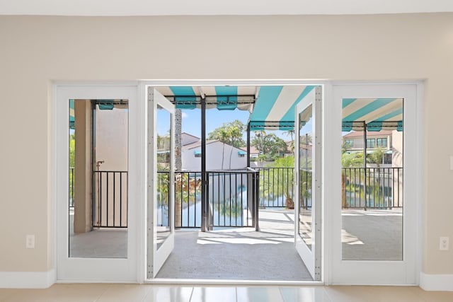 entryway featuring baseboards, tile patterned floors, and a healthy amount of sunlight