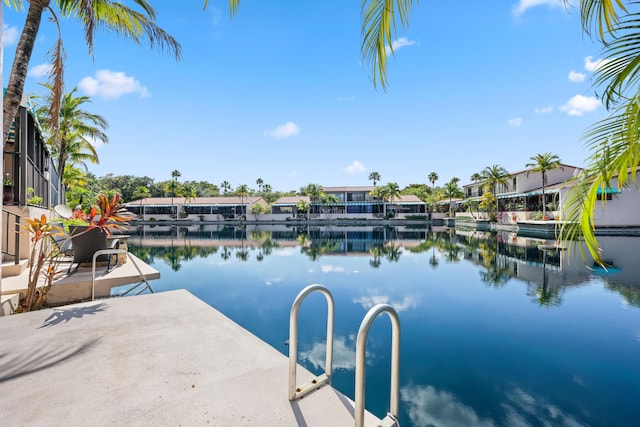 view of swimming pool featuring a water view and a dock