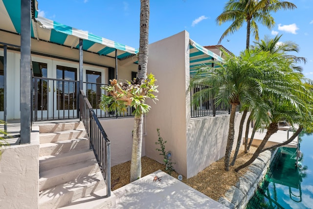 view of home's exterior with stucco siding and french doors