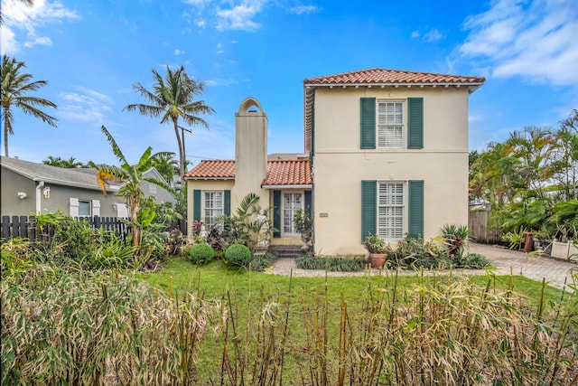 332 Monceaux Rd, West Palm Beach, FL 33405 - mediterranean / spanish house with a tiled roof, stucco siding, fence, and a chimney