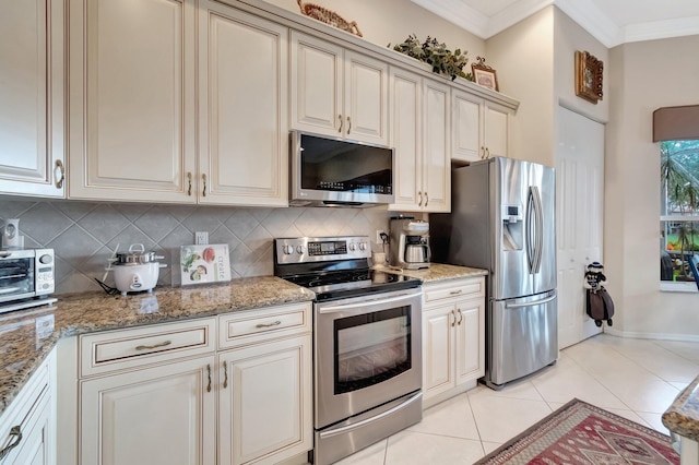 kitchen with tasteful backsplash, crown molding, stainless steel appliances, and light tile patterned floors