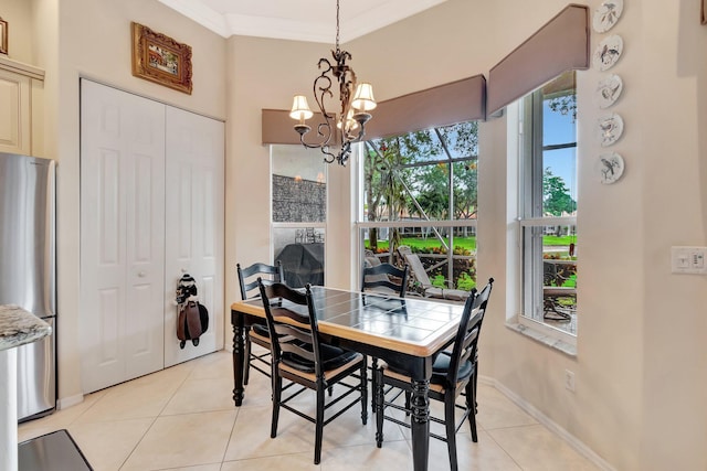 dining area with crown molding, a chandelier, and light tile patterned flooring