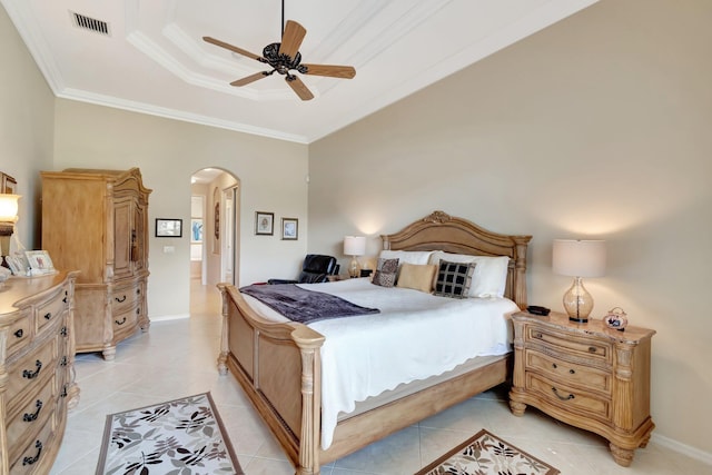 bedroom with arched walkways, ornamental molding, a tray ceiling, and visible vents