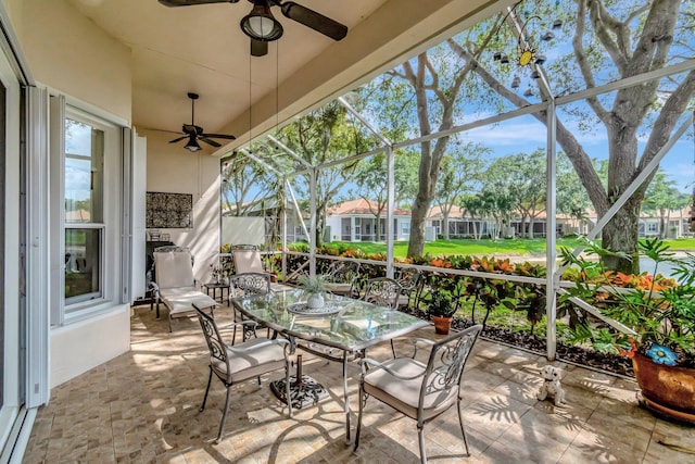 view of patio featuring a residential view, a ceiling fan, a lanai, and outdoor dining area