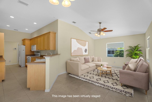 living room featuring a ceiling fan, visible vents, vaulted ceiling, and light tile patterned floors