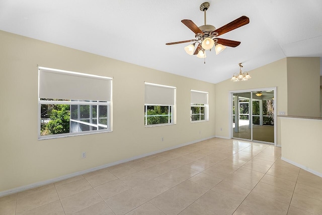 spare room with a healthy amount of sunlight, tile patterned flooring, and ceiling fan with notable chandelier