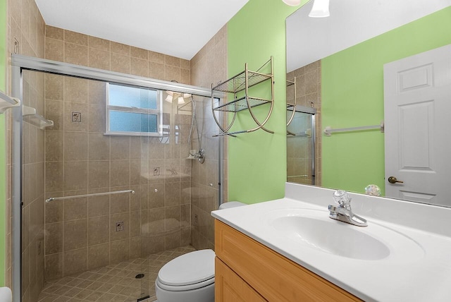 bathroom featuring a shower stall, toilet, and vanity