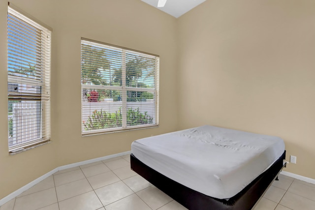 bedroom with baseboards, multiple windows, and light tile patterned floors