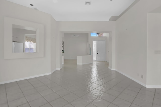 empty room with baseboards, visible vents, and light tile patterned floors