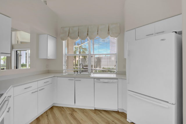kitchen featuring white appliances, light countertops, a sink, and a healthy amount of sunlight