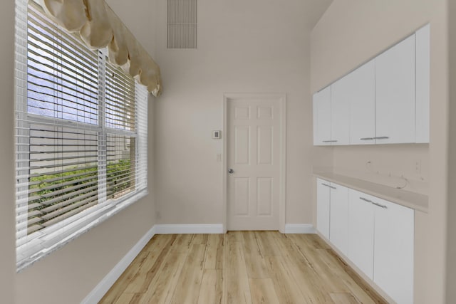 unfurnished dining area with baseboards and light wood-style floors