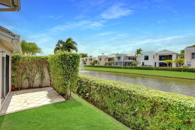 view of yard featuring a water view, a patio area, and a residential view