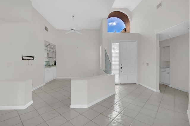 foyer featuring light tile patterned flooring, high vaulted ceiling, a ceiling fan, baseboards, and visible vents